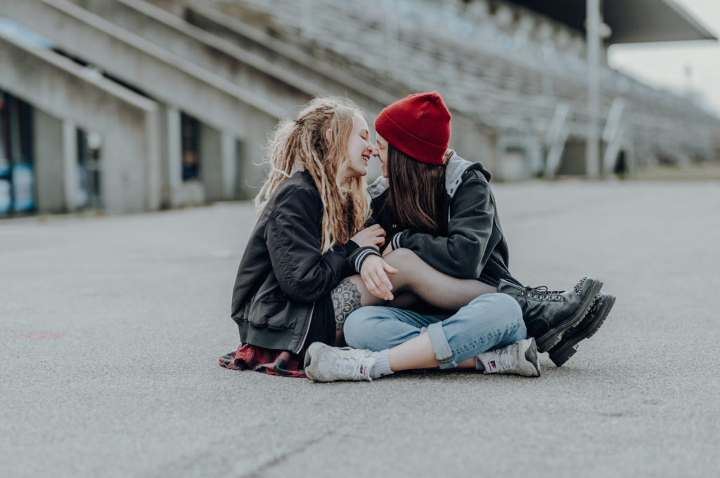 Portraitaufnahme eines kuschelnden Pärchens an der Ruderregatta in München | Portraitfotografin in der Region München Ammersee Fürstenfeldbruck