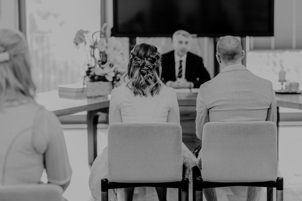 Schwarzweißaufnahme Brautpaar von hinten im Trausaal während der Trauung| Fotografin in Landsberg am Ammersee Fürstenfeldbruck München