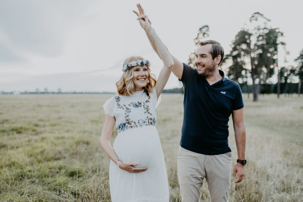 Tanzendes paar in der Natur bei einem Babybauchshooting.