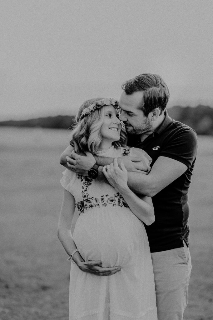 Lachendes Paar bei einem Babybauchshooting in München.