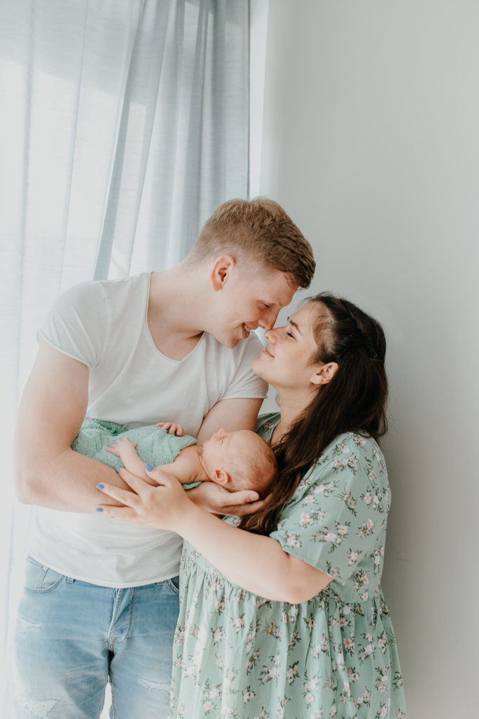Fotografie einer Familie die ihr Kind in den Armen hält.