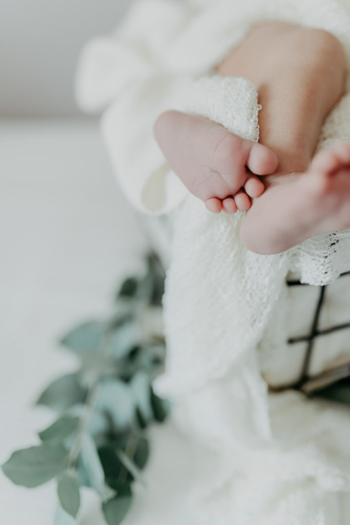 Nahaufnahme von Babyfüßen. Neugeborenenfotografie zu Hause als Homestory.
