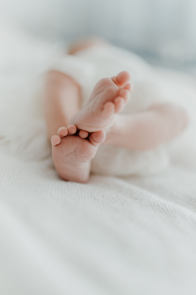 Nahaufnahme von Babyfüßen. Neugeborenenfotografie zu Hause als Homestory.
