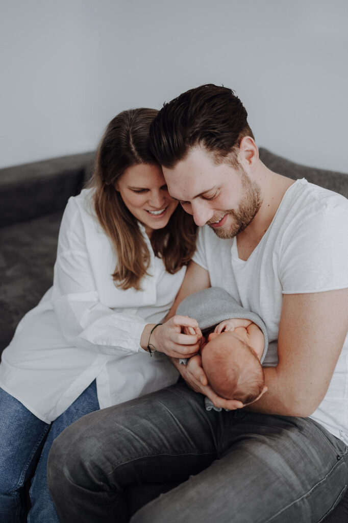 Familienbild von junger Familie mit Neugeborenen.