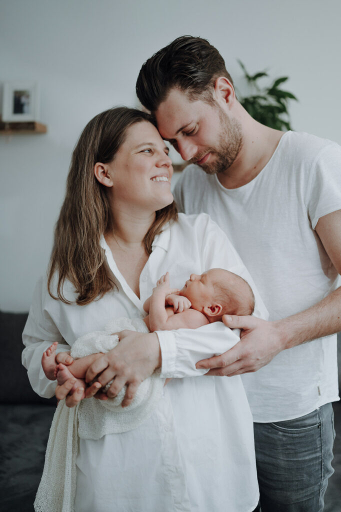 Familienbild von junger Familie mit Neugeborenen.