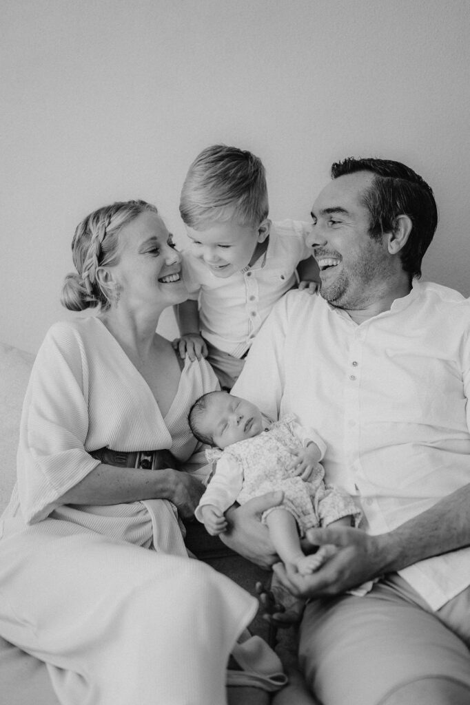 Familienbild von junger Familie mit Neugeborenen.