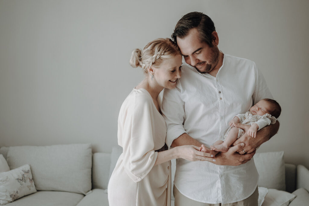 Familienbild von junger Familie mit Neugeborenen.