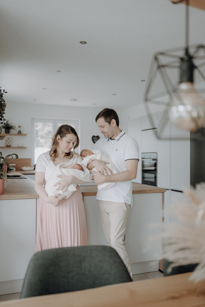 Familienbild von junger Familie mit Neugeborenen.