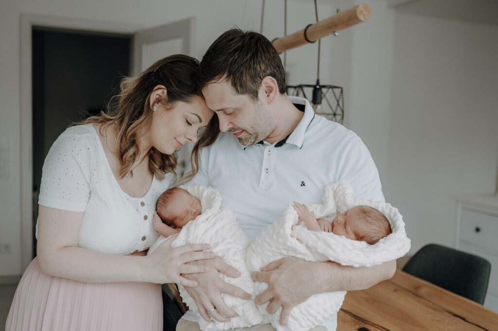Familienbild von junger Familie mit Neugeborenen.